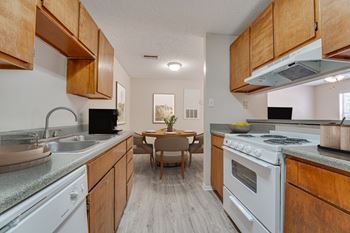 Galley kitchen with wood cabinets and dining area